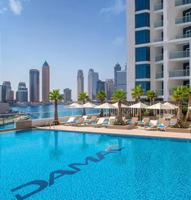 a swimming pool with chairs and a city skyline at Studio with Pool & Canal Views - Near Dubai Mall - Downtown in Dubai