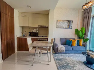 a living room with a blue couch and a table at BurjKhalifa View | 1BR Business Bay Near Dubaimall in Dubai