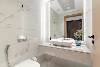 a white bathroom with a sink and a toilet at VayK - Luxury Living with Top Amenities 1BD in JVC in Dubai
