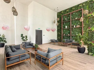 a living room with couches and a wall of plants at VayK - Luxury Living with Top Amenities 1BD in JVC in Dubai