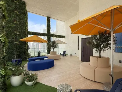 a lobby with chairs and umbrellas in a building at VayK - Luxury Living with Top Amenities 1BD in JVC in Dubai