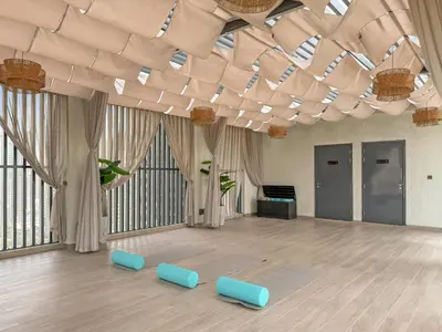 a large room with blue chairs and a ceiling with windows at VayK - Luxury Living with Top Amenities 1BD in JVC in Dubai