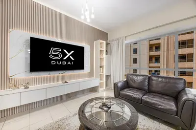 a living room with a couch and a flat screen tv at FiveX Premium 4BR Beachfront Living at JBR in Dubai