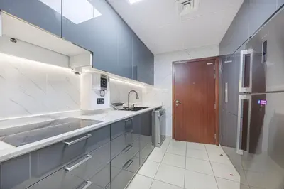 a large kitchen with a sink and a brown door at FiveX Premium 4BR Beachfront Living at JBR in Dubai