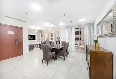 a dining room and living room with a table and chairs at FiveX Premium 4BR Beachfront Living at JBR in Dubai