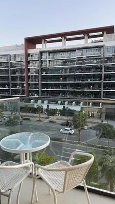 a balcony with a table and chairs and a large building at VESTA - Dubai Residence in Dubai