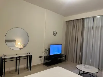 a living room with a television and a mirror at VESTA - Dubai Residence in Dubai