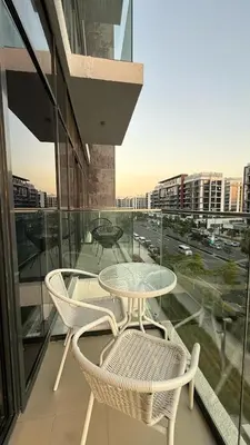 a table and chairs on a balcony with a view of a city at VESTA - Dubai Residence in Dubai