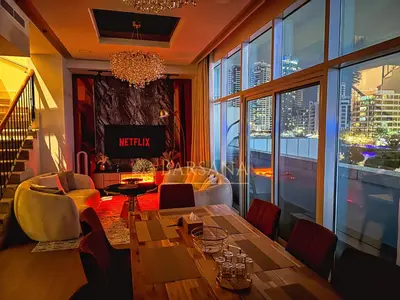 a living room with a table and a view of a city at Barsana - Jumeirah Beach Villa - 2BDR - Marina Views in Dubai