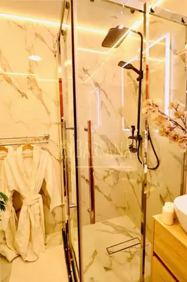 a shower stall in a bathroom with a robe at Barsana - Jumeirah Beach Villa - 2BDR - Marina Views in Dubai