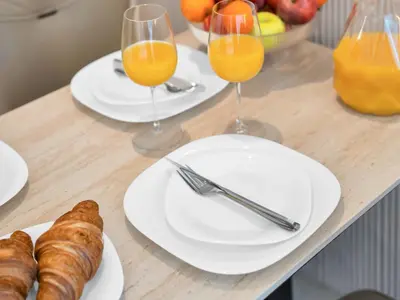 a table with plates of food and glasses of orange juice at Cozy modern STUDIO in STERLING DOWNTOWN I DUBAI MALL I Sleeps 4 in Dubai