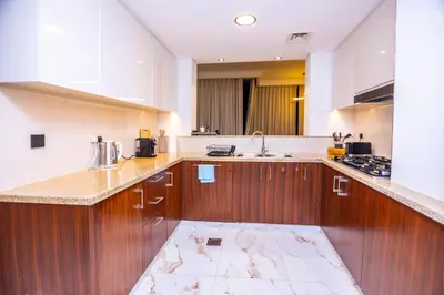 a large kitchen with wooden cabinets and a sink at Luxury 3 BR Premium Feel Iconic Burj View Connected To Dubai Mall in Dubai