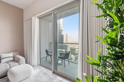 a living room with a couch and a glass window at Grande Signature Residences in Dubai