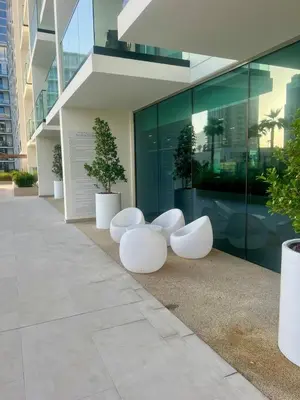 three white chairs sitting outside of a building at Stylish Dubai Stay, Pool, Padel, Gym, Concierge in Dubai