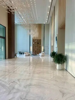 a large lobby with a large marble floor and a building at Stylish Dubai Stay, Pool, Padel, Gym, Concierge in Dubai
