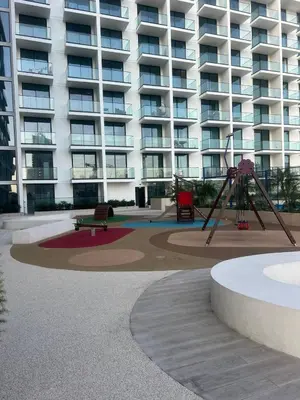 a playground in front of a large apartment building at Stylish Dubai Stay, Pool, Padel, Gym, Concierge in Dubai