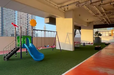 a play area with a slide and a playground at Elite LUX Holiday Homes - Cozy Studio at Al Waleed Garden 2, Dubai in Dubai