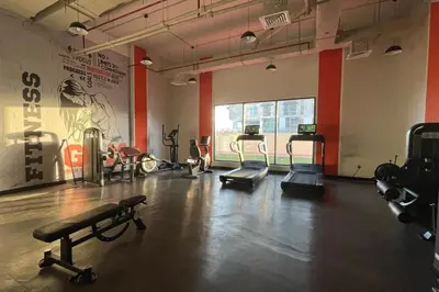 a gym with several exercise equipment in a room at Elite LUX Holiday Homes - Cozy Studio at Al Waleed Garden 2, Dubai in Dubai