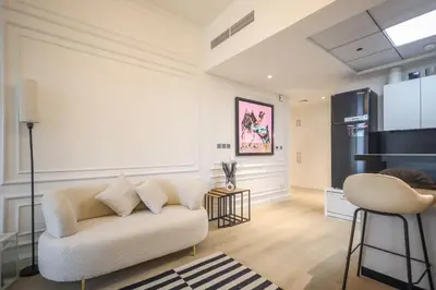 a living room with a couch and a kitchen at Elite LUX Holiday Homes - Cozy Studio at Al Waleed Garden 2, Dubai in Dubai