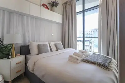 a bedroom with a large bed with towels on it at Elite LUX Holiday Homes - Cozy Studio at Al Waleed Garden 2, Dubai in Dubai