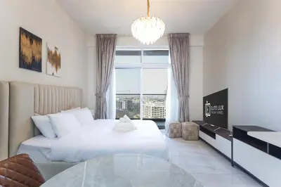 a hotel room with a bed and a glass table at Elite LUX Holiday Homes - Stylish Studio at Jewelz by Danube, Dubai in Dubai
