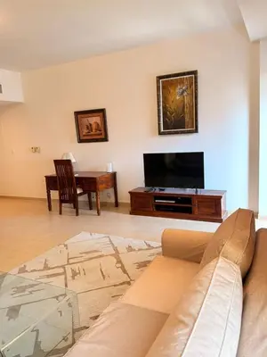 a living room with a couch and a flat screen tv at Spacious & classic Apartment in center of JBR in Dubai