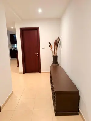 a hallway with a wooden door and a brown table at Spacious & classic Apartment in center of JBR in Dubai