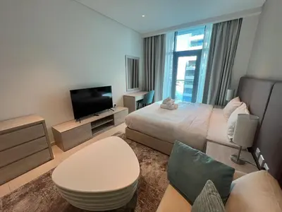a hotel room with a bed and a television at Cozy Studio with Private Beach in Dubai