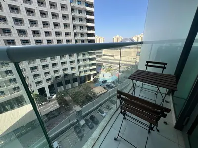 a balcony with two chairs and a table on a building at Cozy Studio with Private Beach in Dubai
