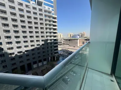 a view of a large building from a glass balcony at Cozy Studio with Private Beach in Dubai