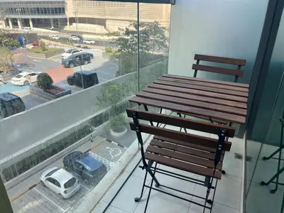 a balcony with a bench and a view of a parking lot at Beach access, next to shopping mall in Dubai