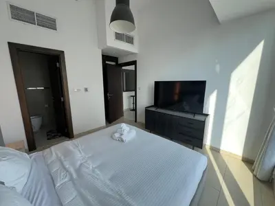 a bedroom with a bed and a flat screen tv at Next to Marina Mall, Close to beach and Metro in Dubai