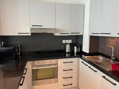 a kitchen with white cabinets and a sink at Next to Marina Mall, Close to beach and Metro in Dubai