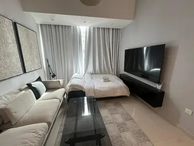 a living room with a couch and a bed at Next to Marina Mall, Close to beach and Metro in Dubai