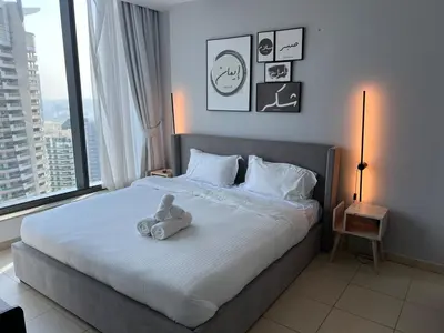 a teddy bear sitting on a bed in a bedroom at Next to Marina Mall, Close to beach and Metro in Dubai