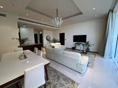 a living room with a white couch and a television at Private beach, Close to Shopping Mall in Dubai
