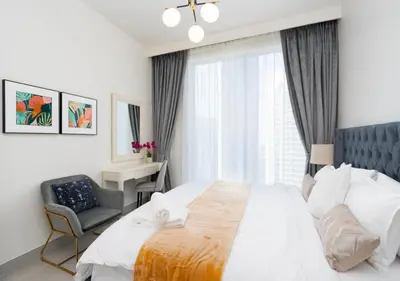 a bedroom with a bed and a chair and a window at Forte Luxury 2BR Apartment with Skyline City Views near Dubai Mall in Dubai