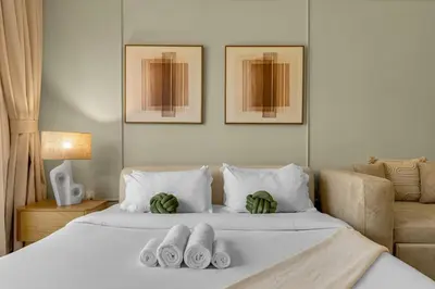 a bedroom with a bed with towels on it at Waves - Modern Studio Retreat W Pool & Gym Access in Dubai