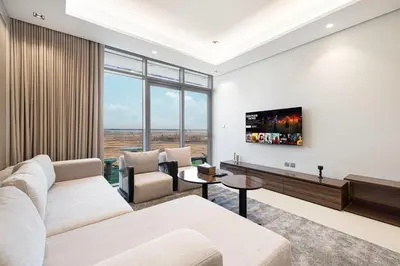 a living room with a couch and a tv at Nobles Suites By Hostiva in Dubai