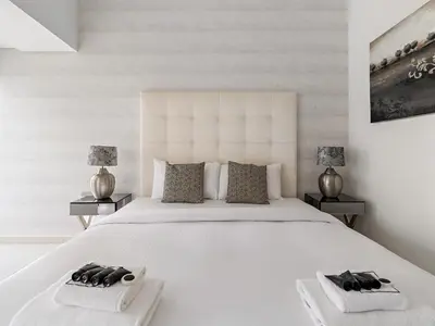 a bedroom with a large white bed with two night stands at Skyline Marina - Modern 2BR Retreat In Cayan-33 in Dubai