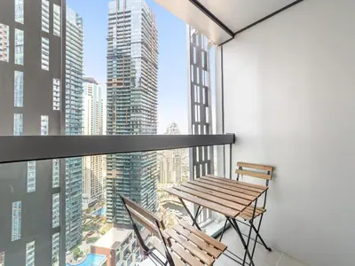 a balcony with a wooden table and two chairs at Skyline Marina - Modern 2BR Retreat In Cayan-33 in Dubai