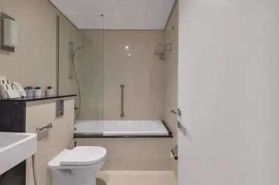 a bathroom with a toilet and a shower and a sink at 3 Bedroom Hotel Apartment with Gym, Spa and Pool in Dubai