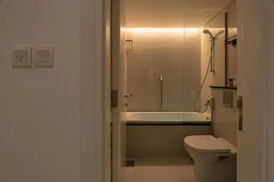 a bathroom with a shower and a toilet and a tub at 3 Bedroom Hotel Apartment with Gym, Spa and Pool in Dubai