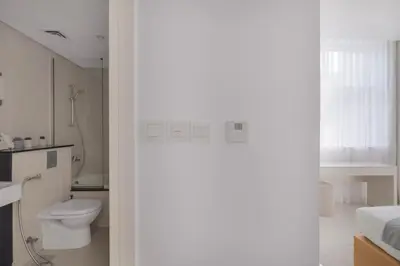 a white bathroom with a toilet and a sink at 3 Bedroom Hotel Apartment with Gym, Spa and Pool in Dubai