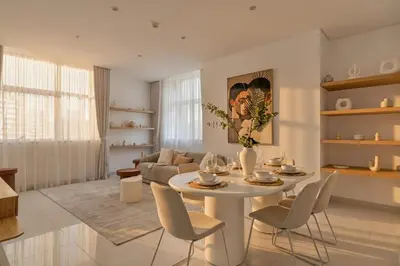 a living room with a white table and chairs at 3 Bedroom Hotel Apartment with Gym, Spa and Pool in Dubai