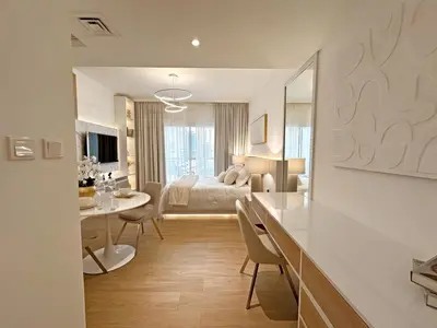 a hotel room with a bed and a dining room at Brand New Studio Downtown, All Bills Included in Dubai