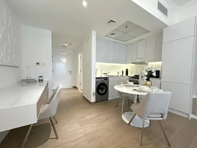 a kitchen and dining room with a table and chairs at Brand New Studio Downtown, All Bills Included in Dubai