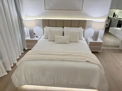 a bedroom with a large white bed with two lamps at Brand New Studio Downtown, All Bills Included in Dubai