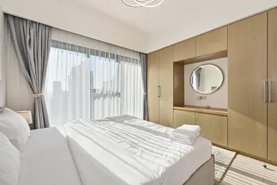 a bedroom with a large bed and a mirror at CH Skyline Bliss 1 BR near Burj Khalifa in Dubai