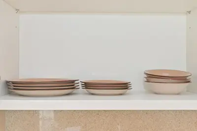 four bowls sitting on a shelf in a kitchen at CH Skyline Bliss 1 BR near Burj Khalifa in Dubai